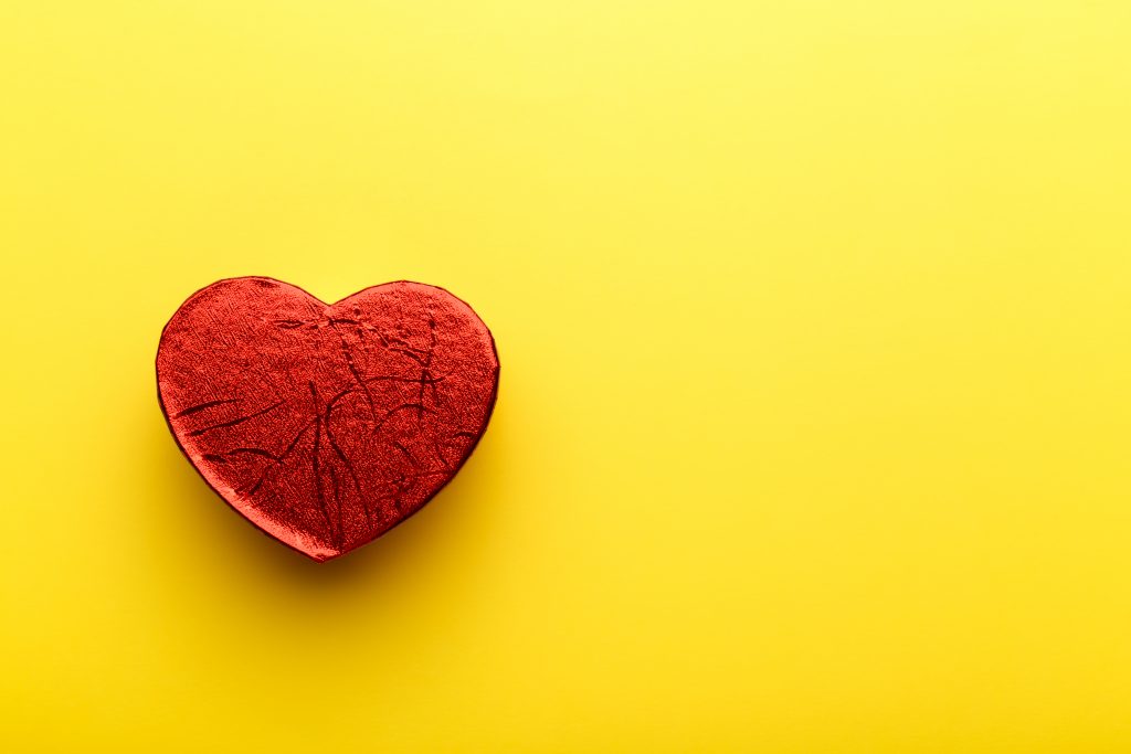Red heart gift box on yellow background