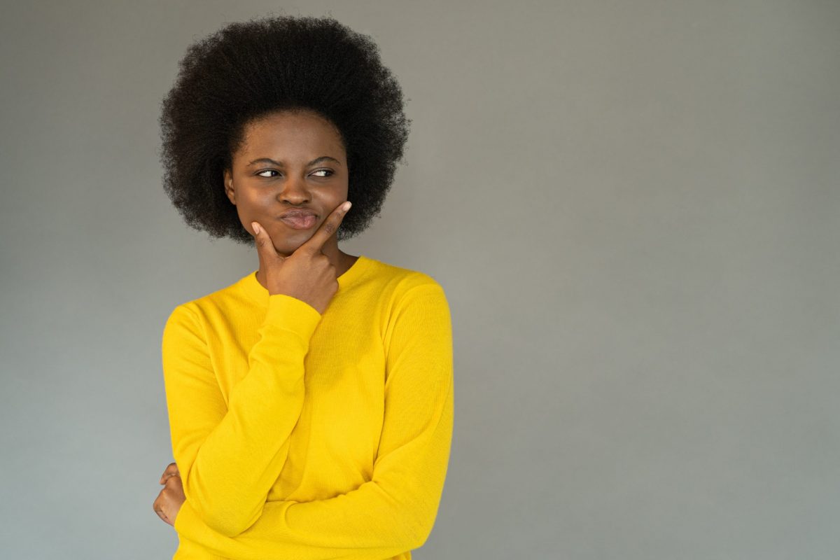 doubtful-young-african-woman-touching-her-chin-sk-2022-11-15-05-11-53-utc